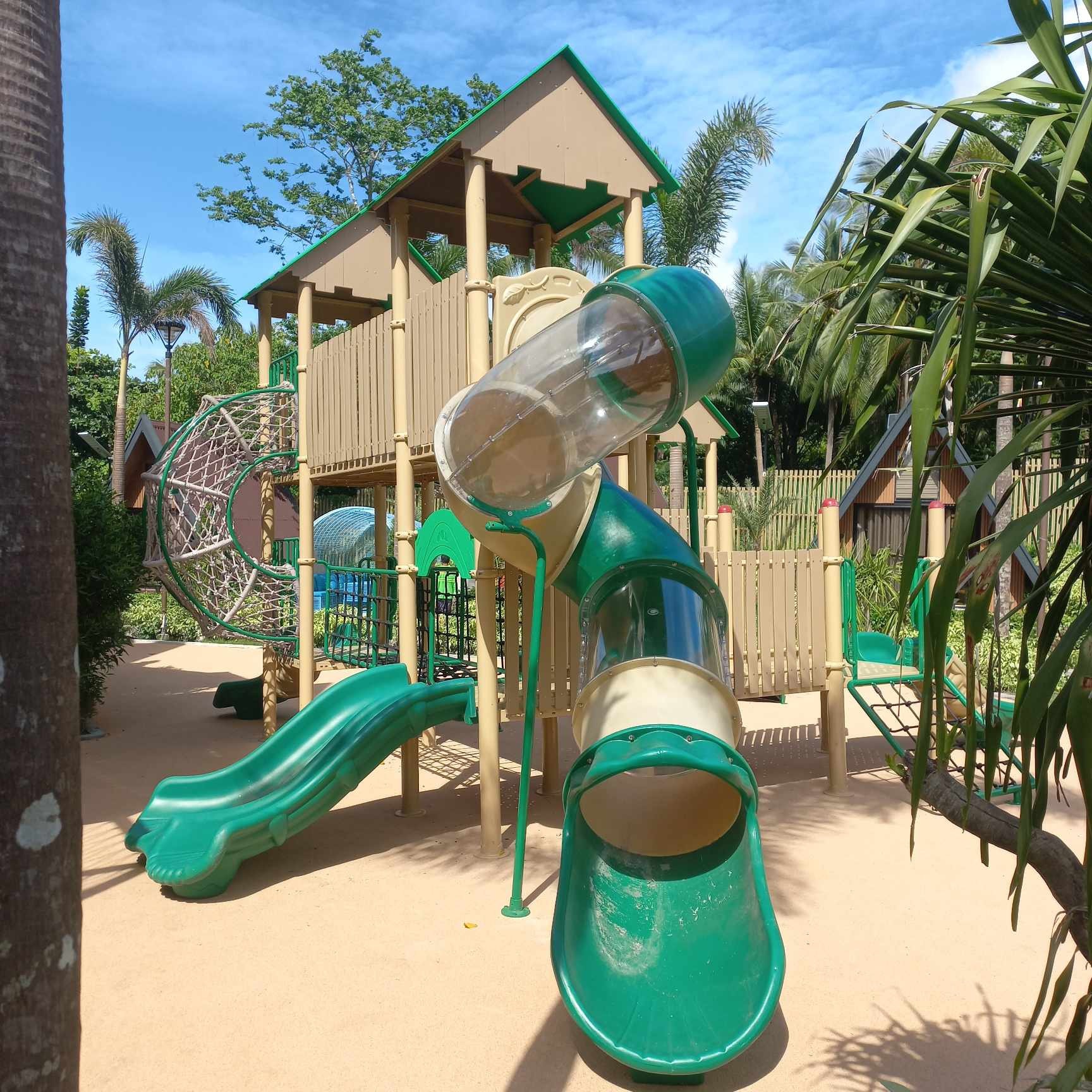 Spielplatz im Freien mit Röhrenrutsche und Kletternetz. Kommerzielle Kinderspielgeräte