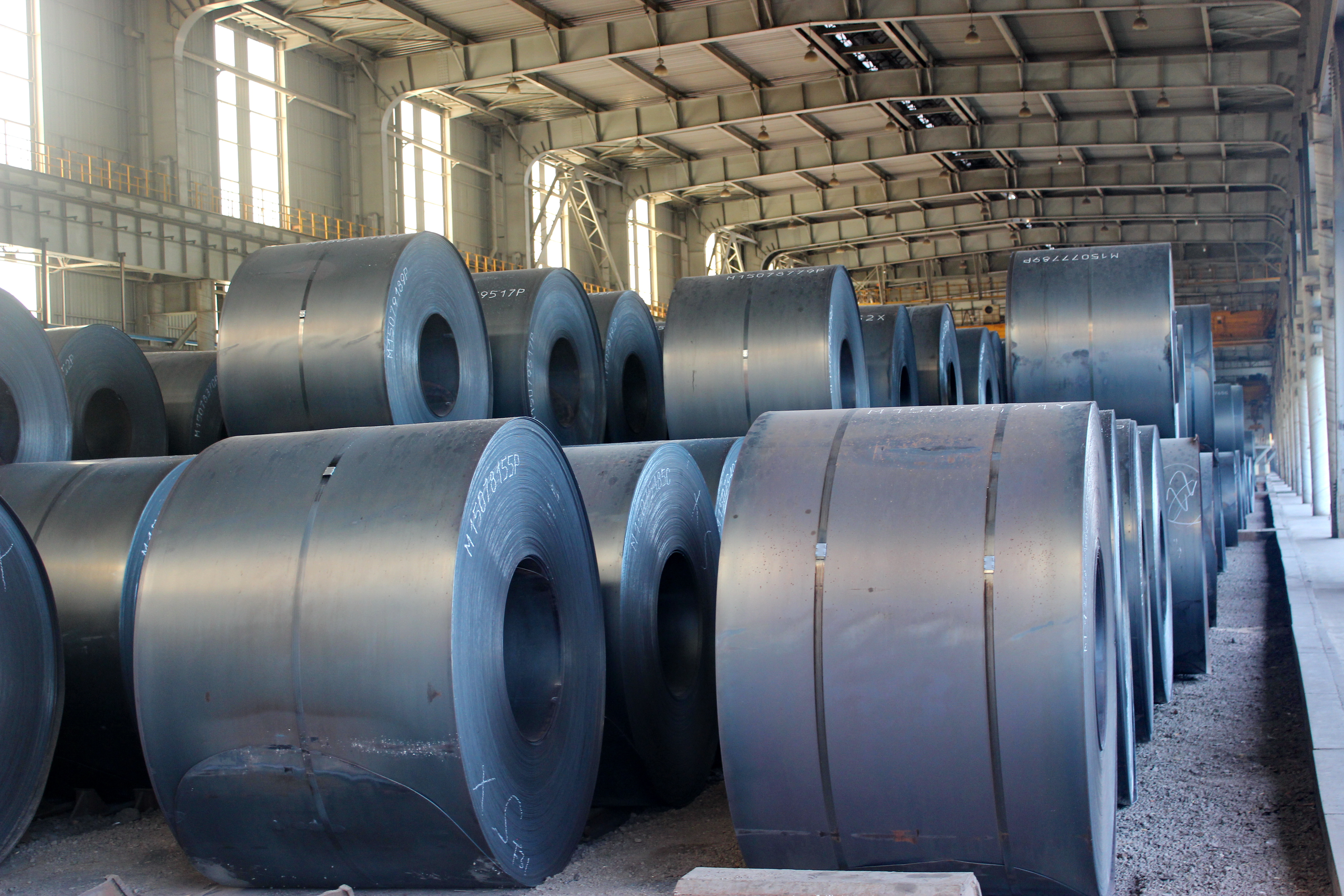 HOT ROLLED STEEL COIL PACKING Bobines d'acier laminées à chaud robustes regroupées en toute sécurité avec des cerclages en acier à haute résistance, empilées dans un entrepôt de stockage.
