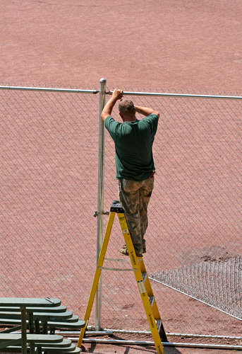 Man-building-chain-link-fence