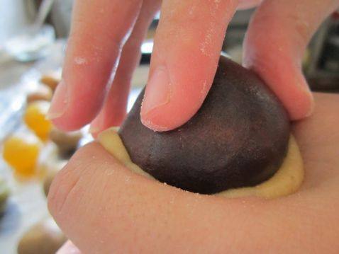 一手拿住馅料，另一只手用虎口把皮往上推