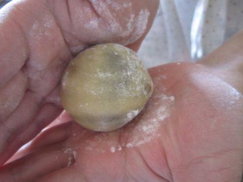 放在手中搓几下，使手粉均匀的沾在月饼团上