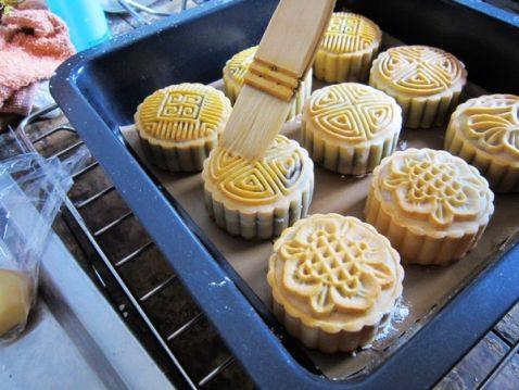 在定好型的月饼坯子上均匀的拍上蛋黄液