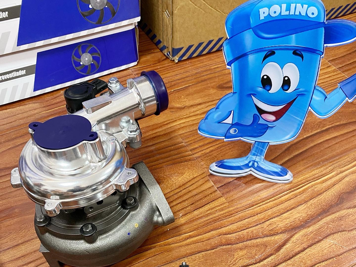 zesp&oacute;ł turbosprężarki trzymany dłonią w rękawiczce, skupiając się na montażu 